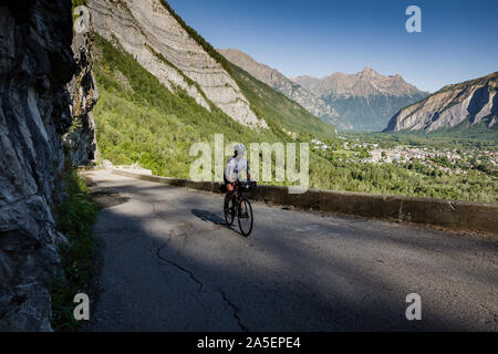 Cycliste de sexe masculin grimpant sur la route du balcon jusqu'à Villard notre Dame, Oisans, France. Banque D'Images