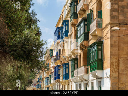 Façade de maison résidentielle traditionnelle maltaise avec balcons en bois clos multicolores à La Valette, Malte, en journée d'été. Banque D'Images