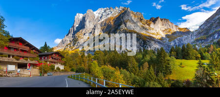 Grindelwald, Suisse street et de l'automne paysage panorama des montagnes des Alpes suisses, chalets en bois sur les champs verts et les hauts sommets en arrière-plan, Berne Banque D'Images