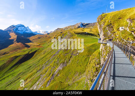 Grindelwald, Suisse - le 10 octobre 2019 : les gens sur sky Cliff walk pont métallique au premier sommet des Alpes suisses, la neige des montagnes, panorama des pics Oberland Banque D'Images