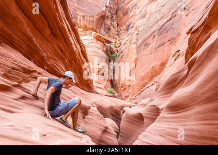 Vague rouge orange et formations de grès abstract man climbing rocks à Antilope canyon fente étroite dans l'Arizona sur le sentier du lac Powell Banque D'Images