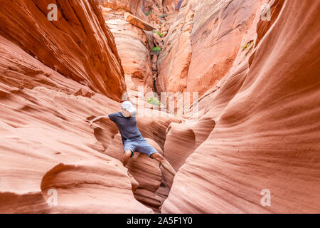 Vague rouge orange des formations de grès et de roches de passage d'escalade homme étroit à l'emplacement de l'Antilope Canyon en Arizona sur le sentier du lac Powell Banque D'Images