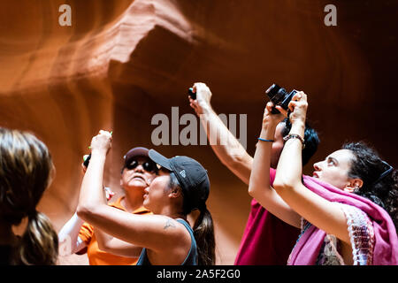 Page, USA - Le 10 août 2019 : Tour groupe de jeunes dans la fente d'Antelope Canyon en Arizona à prendre des photos avec l'appareil photo de grès formatio Banque D'Images