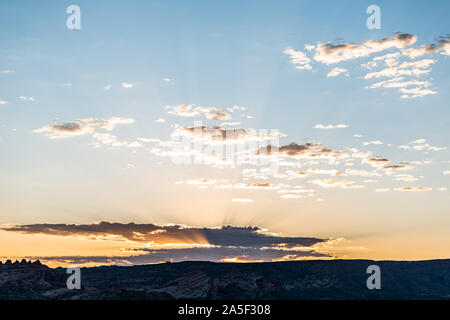 Vue du lever du soleil coloré Skyscape avec soleil derrière les nuages et les rayons du soleil au moyen de poutres avec horizon sky valley dans Arches National Park, Utah, USA Banque D'Images