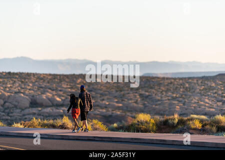 Moab, États-Unis - 14 août 2019 : lever de soleil dans la vallée de Arches National Park, Utah matin avec jeune couple walking on donnent sur fournaise ardente Viewpoi Banque D'Images