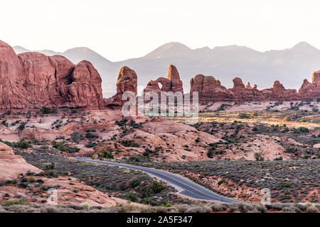 High angle Vue aérienne de route menant à la fenêtre arch dans Arches National Park dans l'Utah pendant morning sunrise avec orange rouge couleur rose rock Banque D'Images