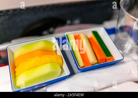 La nourriture végétalienne saine vgml snack-repas sur voyage en avion avec un dessert de fruits melon vert orange en tranches et des bâtonnets de concombre Banque D'Images