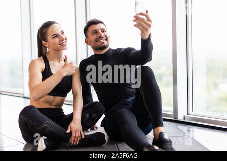 Jeune couple à selfies sport. L'homme et la femme athlète taking photo sur smartphone avoir pause après la formation, copy space Banque D'Images