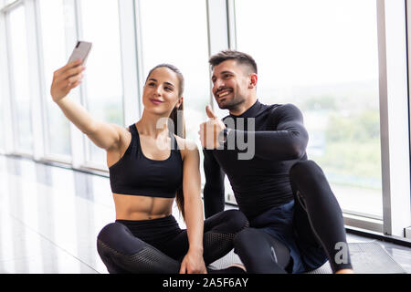 Jeune couple à selfies sport. L'homme et la femme athlète taking photo sur smartphone avoir pause après la formation, copy space Banque D'Images