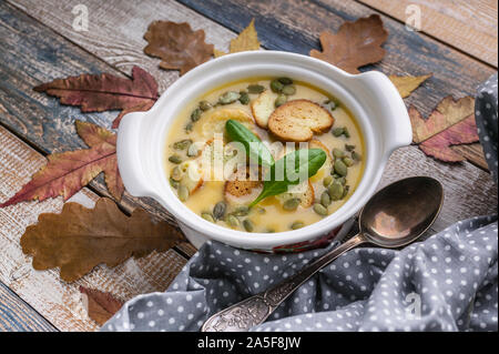 La soupe aux légumes d'automne, croûtons, graines de potiron et d'épinards frais sur un fond rustique. Vue d'en haut Banque D'Images