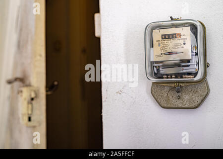 Compteur d'électricité sur un mur blanc. Un dispositif de mesure de la consommation de courant électrique. Fond clair. Banque D'Images