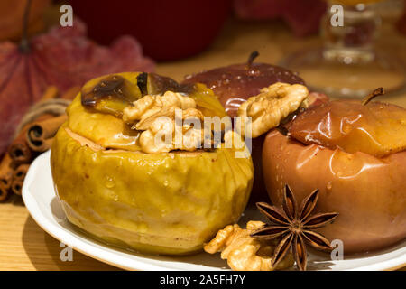 Pommes cuites à la cannelle et anis étoile, farcies aux noix et raisins secs. Sain et savoureux automne noël dessert. Close up. Banque D'Images