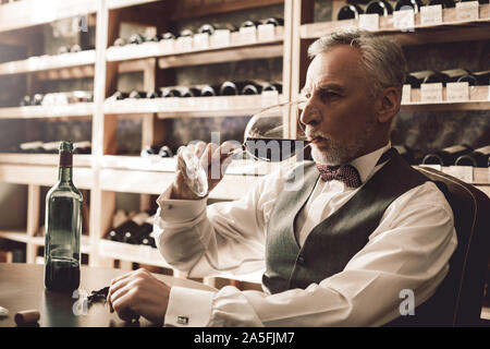 Sommelier Concept. Senior dégustation vin rouge concentré close-up Banque D'Images