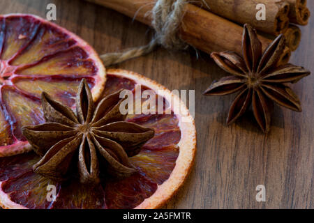 Orange sicilienne séché et séchés tranche de citron avec des bâtons de cannelle et anis étoile sur fond de bois brun, Close up. Macro. Ambiance de Noël backgroun Banque D'Images