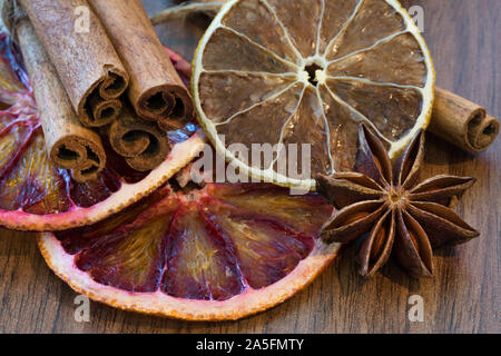 Orange sicilienne séché et séchés tranche de citron avec des bâtons de cannelle et anis étoile sur fond de bois brun, Close up. Macro. Ambiance de Noël backgroun Banque D'Images