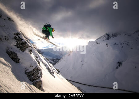 La skieuse acrobatique de sauter un rocher au coucher du soleil dans les Alpes autrichiennes, 6600, Salzbourg, Autriche Banque D'Images