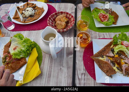 Crêpes sucrées et salées sur la table, une cuisine française jug, verres de cidre. Les minces crêpes délicat peut être rempli avec tout ce que vous aimez. Banque D'Images
