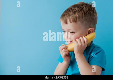 Petit garçon essaie de parler à l'aide d'une banane au lieu de téléphone Banque D'Images