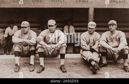 La photographie montre George Herman Ruth, "Babe" Ernest G. 'Ernie Shore', 'George Foster, Rube' et 'DEL' Dellos Gainer, face à l'avant, le port de Boston Red Sox Baseball uniformes d'équipe, assis sur un muret en face d'un étang. Banque D'Images