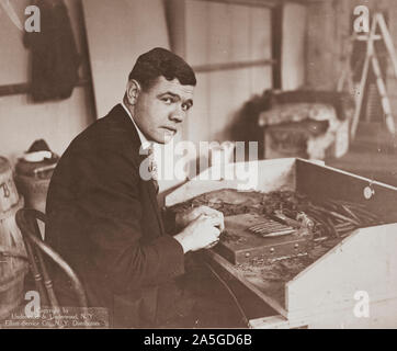 La photographie montre George Herman Ruth, "Babe" portrait de mi-longueur, assis, en face légèrement à droite, le roulement d'un cigare. Banque D'Images