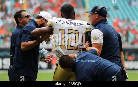 19 octobre 2019 : Georgia Tech Yellow Jackets linebacker Bruce Jordan-Swilling (12) reçoit de l'aide hors du terrain, en raison d'une blessure inconnue, par Georgia Tech medical et coaching personnel pendant un match de football contre le collège Les ouragans à Miami le Hard Rock Stadium de Miami Gardens, en Floride. Georgia Tech a gagné 28-21 en prolongation. Mario Houben/CSM Banque D'Images