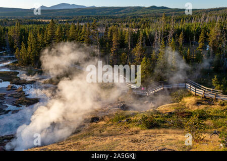 Coucher de soleil sur piste comme Paintpot Artistes passe de la vapeur les geysers et sources chaudes à Parc National de Yellowstone dans le Wyoming, USA. Banque D'Images