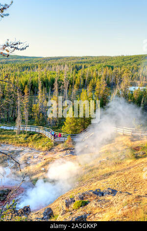 Coucher de soleil sur piste comme Paintpot Artistes passe de la vapeur les geysers et sources chaudes à Parc National de Yellowstone dans le Wyoming, USA. Banque D'Images