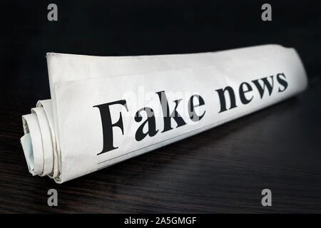 Fake News Journal sur 24 dans le bureau. Actualités en gros titre de journal lecture fake news concept pour faux titre de nouvelles de l'événement. Journal enroulé. Banque D'Images