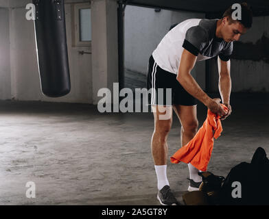 Un beau jeune sportsman changer de vêtements après une formation fort Banque D'Images