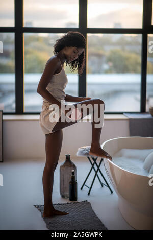 La peau foncée Slim woman enjoying procédures spa à la maison Banque D'Images