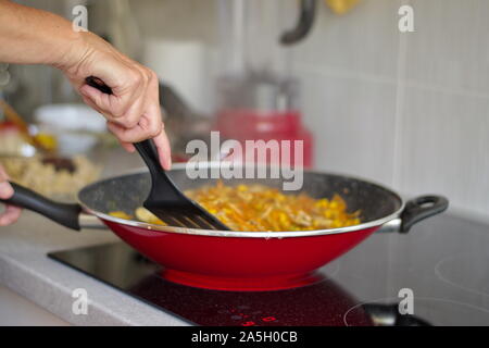 Au milieu de la cuisson sur la cuisinière femme Banque D'Images