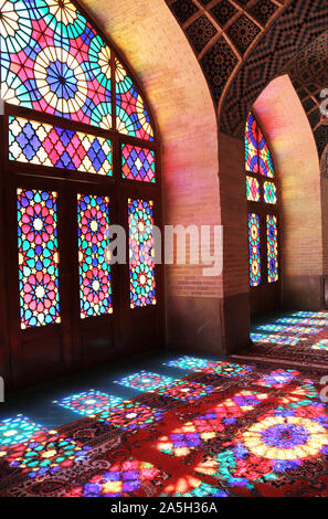 Beaux modèles de la lumière du soleil sur les tapis par multi-couleur des vitraux. Intérieur de Nasir al-Mulk mosquée (mosquée Rose) à Shiraz, Iran Banque D'Images