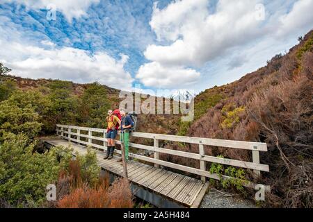Randonneurs sur pont, sentier de randonnée pédestre Circuit Nord de Tongariro, Grande Marche, le volcan Mont Tongariro et Ngauruhoe Mont, Parc National de Tongariro, Nord Banque D'Images