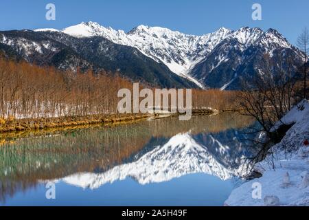 Montagnes couvertes de neige à un lac, Alpes Japonaises reflète dans l'Étang Taisho, Mont Hotaka couvert de neige à l'arrière, Kamikochi, Matsumoto, Nagano, Japon Banque D'Images