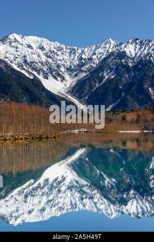 Montagnes couvertes de neige à un lac, Alpes Japonaises reflète dans l'Étang Taisho, Mont Hotaka couvert de neige à l'arrière, Kamikochi, Matsumoto, Nagano, Japon Banque D'Images