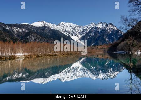 Montagnes couvertes de neige à un lac, Alpes Japonaises reflète dans l'Étang Taisho, Mont Hotaka couvert de neige à l'arrière, Kamikochi, Matsumoto, Nagano, Japon Banque D'Images