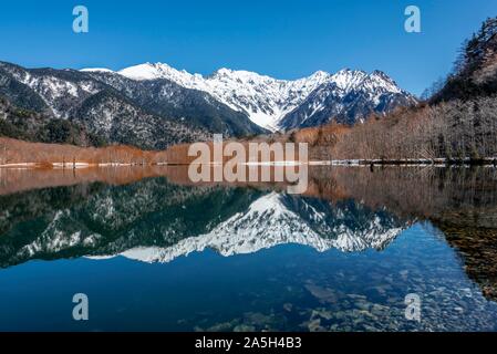 Montagnes couvertes de neige à un lac, Alpes Japonaises reflète dans l'Étang Taisho, Mont Hotaka couvert de neige à l'arrière, Kamikochi, Matsumoto, Nagano, Japon Banque D'Images