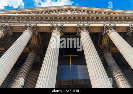 Ange-shot basse de l'église catholique romaine La Madeleine à Paris. Les impressionnantes colonnes sont maintenant le fronton sculpté montrant le dernier... Banque D'Images