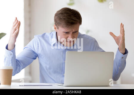 Angry middle aged businessman looking at laptop écran. Banque D'Images