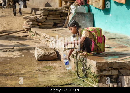 Bundi, Inde - 19 Février 2019 : Indian girl verser de l'eau en bouteille sur la rue Banque D'Images