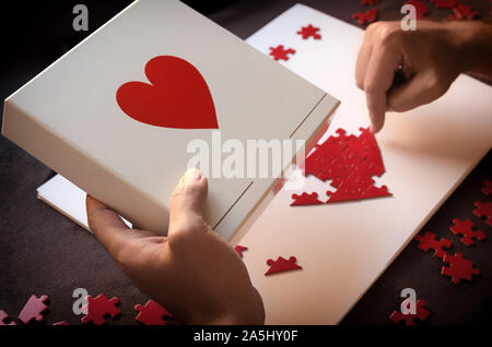 Faire de l'homme en forme de coeur rouge casse-tête. Concept pour donner de l'amour ou faire la charité. Chaque petit geste compte Banque D'Images