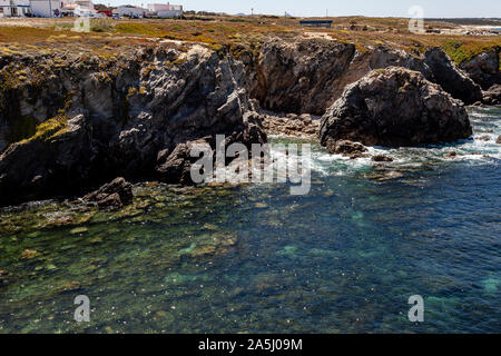 Crystal Clear cove où vous pouvez voir le fond à travers elle et une partie du village de 'Porto Covo' perché sur sa falaise. Banque D'Images
