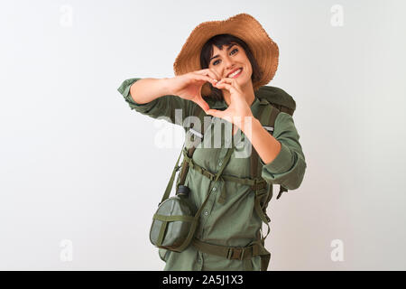 Sac à dos Hiker woman wearing hat et de l'eau sur fond blanc isolé de cantine en souriant aime faire symbole coeur forme avec les mains. Concep romantique Banque D'Images