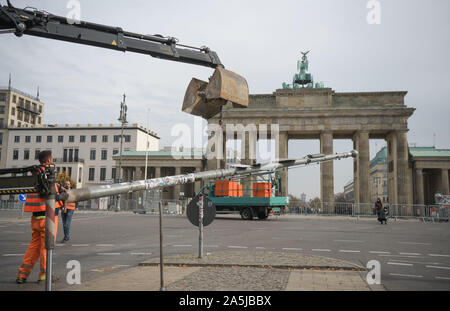 Berlin, Allemagne. 21 Oct, 2019. En raison de travaux de construction de la rue festival '30 ans révolution pacifique - Chute du mur', un panneau de circulation est démantelé à la porte de Brandebourg sur la Straße des 17. Juni. Du 04 au 10 novembre, de nombreux événements auront lieu à Berlin sous la devise '30 ans de la révolution pacifique - Chute du mur' à sept emplacements d'origine de la révolution pacifique. Credit : Jörg Carstensen/dpa/Alamy Live News Banque D'Images