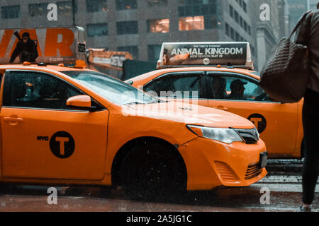 New York : Yellow taxi cab vitesse dans le trafic important du centre-ville de New York un jour de pluie. East 42nd strret, dans l'état de mauvais temps nuageux Banque D'Images