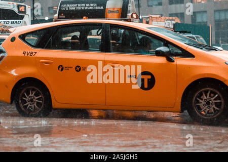 New York, 2017 : Yellow taxi cab vitesse dans le trafic important du centre-ville de New York un jour de pluie. East 42nd Street, New York. Cloudy Stormy Weather Banque D'Images