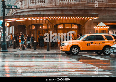 New York, 2017 : Yellow taxi cab vitesse dans le trafic important du centre-ville de New York un jour de pluie. East 42nd Street, New York. Cloudy Stormy Weather Banque D'Images