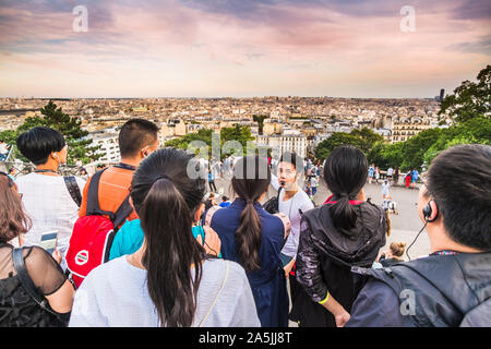 Les touristes asiatiques à l'écoute de guide sur l'escalier de la basilique du Sacré-cœur Banque D'Images