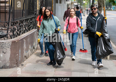 De vrais gens aident à nettoyer les rues pendant la cocotte à Santiago. L'armée est sortie dans les rues pour dissoudre les manifestants du peuple Banque D'Images