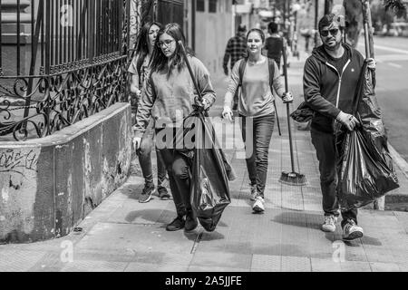 De vrais gens aident à nettoyer les rues pendant la cocotte à Santiago. L'armée est sortie dans les rues pour dissoudre les manifestants du peuple Banque D'Images